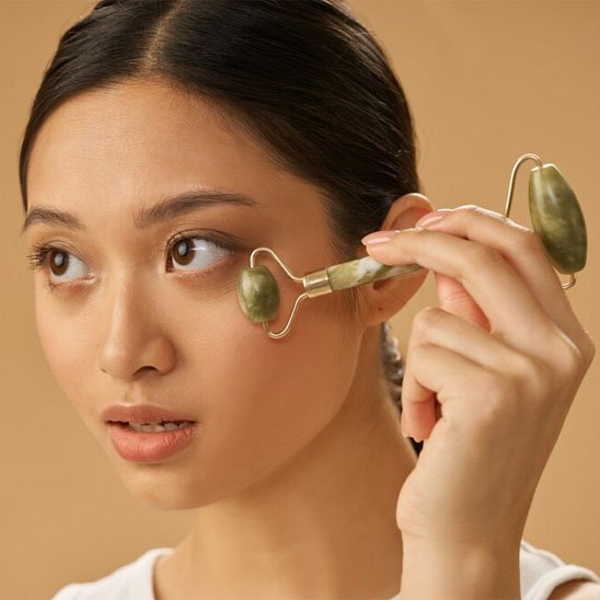 Gua sha visage sur joue femme pensive