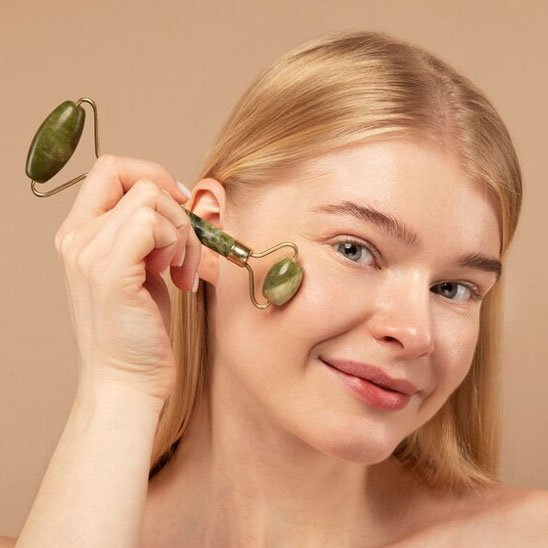 Gua sha visage sur joue femme souriante yeux ouverts